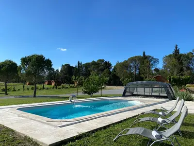 a swimming pool with two lawn chairs around it at Échappée Vigneronne in Pennautier