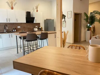 a kitchen with white cabinets and a table and chairs at Villa de charme avec spa in Pamiers