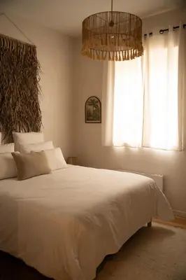 a bedroom with a large white bed with a chandelier at Villa de charme avec spa in Pamiers