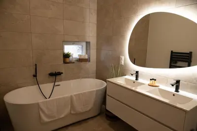 a bathroom with a tub and a sink and a mirror at Villa de charme avec spa in Pamiers