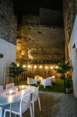 a patio with a table and chairs and a brick wall at Villa de charme avec spa in Pamiers