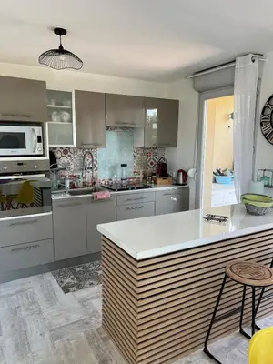 a kitchen with white cabinets and a white counter top at Appartement vue château in Carcassonne