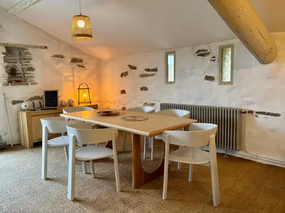 a dining room with a table and white chairs at Bergerie bonheur! in Port-la-Nouvelle
