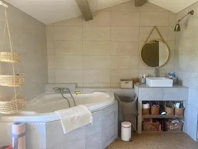 a bathroom with a tub and a sink and a mirror at Bergerie bonheur! in Port-la-Nouvelle