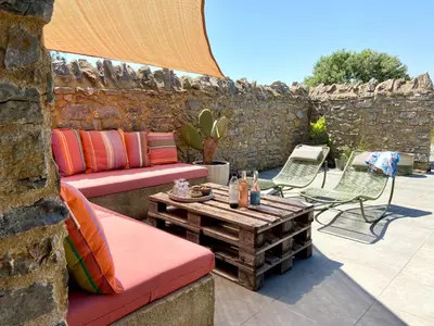 a patio with a couch and a table and chairs at Bergerie bonheur! in Port-la-Nouvelle