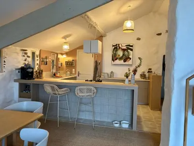 a kitchen with a counter and two stools at Bergerie bonheur! in Port-la-Nouvelle