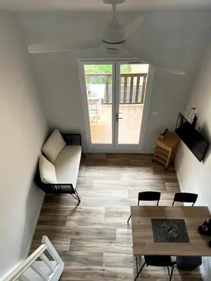 a living room with a table and chairs at La franqui , nouveau , Duplex pour 2 ou 3 ,piscine, mer ,soleil , station familiale in La Franqui-Plage