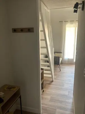 a room with a staircase and a room with a table at La franqui , nouveau , Duplex pour 2 ou 3 ,piscine, mer ,soleil , station familiale in La Franqui-Plage