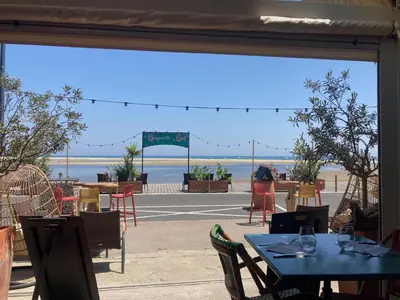 a view of a patio with tables and chairs at La franqui , nouveau , Duplex pour 2 ou 3 ,piscine, mer ,soleil , station familiale in La Franqui-Plage