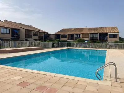 a swimming pool in front of some apartment buildings at La franqui , nouveau , Duplex pour 2 ou 3 ,piscine, mer ,soleil , station familiale in La Franqui-Plage