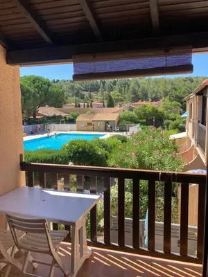 a balcony with a table and a view of a pool at La franqui , nouveau , Duplex pour 2 ou 3 ,piscine, mer ,soleil , station familiale in La Franqui-Plage