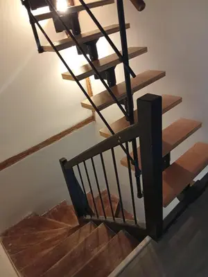 a stairwell with a black rail and wooden stairs at La Céliane- climatisé avec patio classé 3 étoiles in Castelnaudary