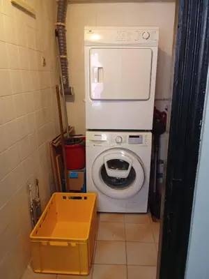 a washer and dryer in a small bathroom at La Céliane- climatisé avec patio classé 3 étoiles in Castelnaudary