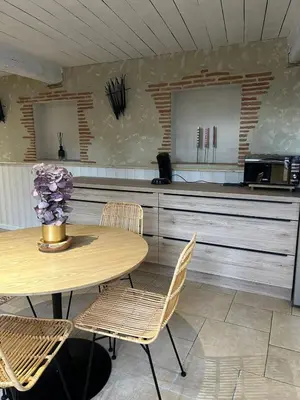 a kitchen with a table and chairs and a counter at Maison loft au cachet ancien in Villasavary
