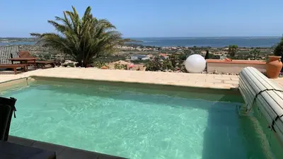 a large swimming pool with a view of the ocean at Villa Hoi An in Fitou