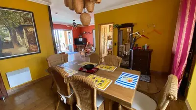 a dining room with a wooden table and chairs at Villa Hoi An in Fitou