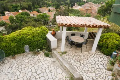 a gazebo with a table and chairs on a patio at Volet verts 8 personnes in Fitou