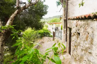 an old house with a stone wall and a walkway at Volet verts 8 personnes in Fitou