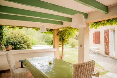 a patio with a table and chairs on a patio at Les hauts de Palaja, villa with pool and parking in Palaja