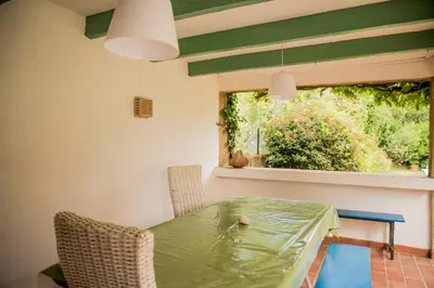 a dining room with a green table and a window at Les hauts de Palaja, villa with pool and parking in Palaja