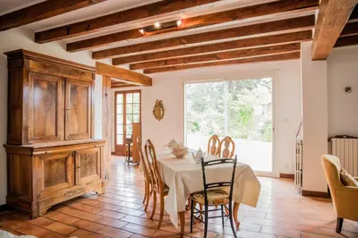 a dining room with a table and chairs at Les hauts de Palaja, villa with pool and parking in Palaja