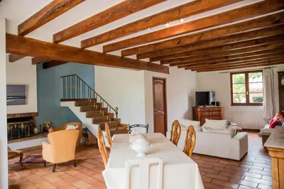 a living room with a table and a couch at Les hauts de Palaja, villa with pool and parking in Palaja