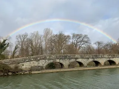 a rainbow over a stone bridge over a river at La Redorte 23 in La Redorte