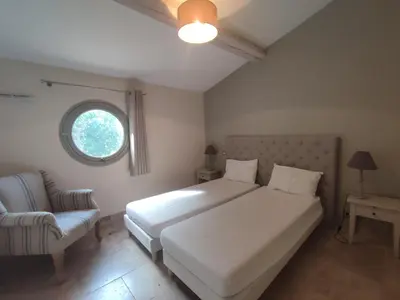 a bedroom with a bed and a chair and a window at La Redorte 23 in La Redorte