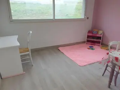 a room with a pink rug and a table and a window at L'arche rose in Nailloux