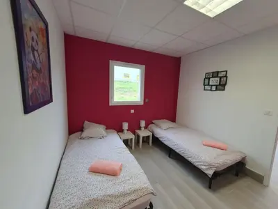 two beds in a room with red and white walls at L'arche rose in Nailloux