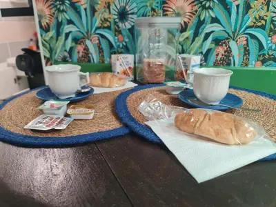 a table with two cups and two croissants and two saucers at La Tropicale, studio climatisé avec parking, Proche Cité médiévale in Carcassonne