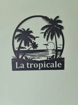a sign with two palm trees on a beach at La Tropicale, studio climatisé avec parking, Proche Cité médiévale in Carcassonne