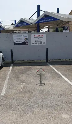 a fire hydrant in a parking lot in front of a building at La Tropicale, studio climatisé avec parking, Proche Cité médiévale in Carcassonne