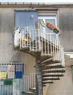 a staircase in front of a building with a window at La Tropicale, studio climatisé avec parking, Proche Cité médiévale in Carcassonne