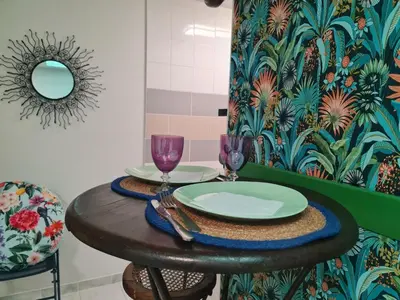 a table with a plate and wine glasses on it at La Tropicale, studio climatisé avec parking, Proche Cité médiévale in Carcassonne