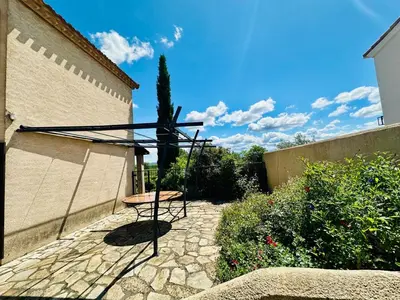 a table and a chair in a courtyard at La maison du canal in Ventenac en Minervois