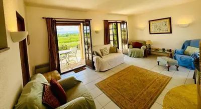 a living room with a couch and chairs and a window at La maison du canal in Ventenac en Minervois