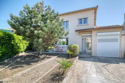 a house with a tree and a garage at La Catalane House T4 Garden Parking in Pamiers