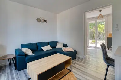 a living room with a blue couch and a table at La Catalane House T4 Garden Parking in Pamiers