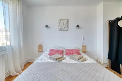 a white bedroom with a bed with two towels on it at La Catalane House T4 Garden Parking in Pamiers