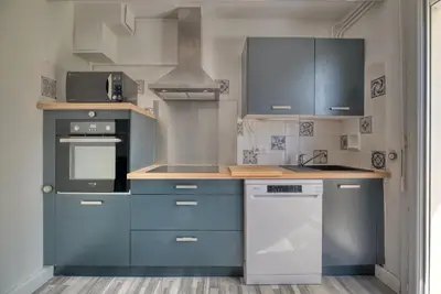a kitchen with blue cabinets and a stove at La Catalane House T4 Garden Parking in Pamiers