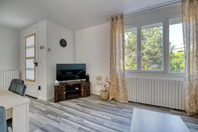 a living room with a television and windows at La Catalane House T4 Garden Parking in Pamiers