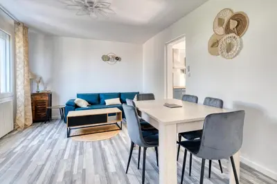 a living room with a table and a blue couch at La Catalane House T4 Garden Parking in Pamiers