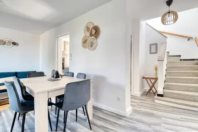 a dining room with a table and chairs and stairs at La Catalane House T4 Garden Parking in Pamiers