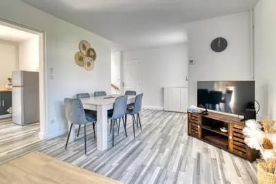 a dining room with a table and chairs and a television at La Catalane House T4 Garden Parking in Pamiers
