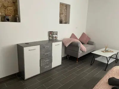 a living room with a dresser and a couch at les bambous in Mas-Saintes-Puelles