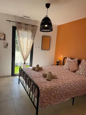 a bedroom with a bed with a flowered blanket at New villa 2025 Pyrenees View, Pool & Comfort in Carcassonne