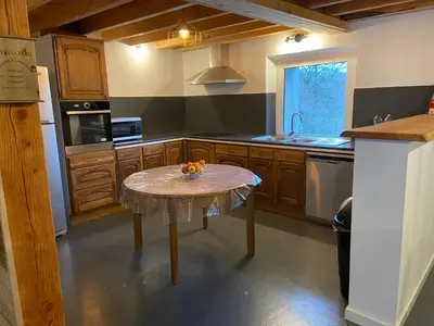 a kitchen with a table with a bowl of fruit on it at Le Grand Gîte in Le Soulié