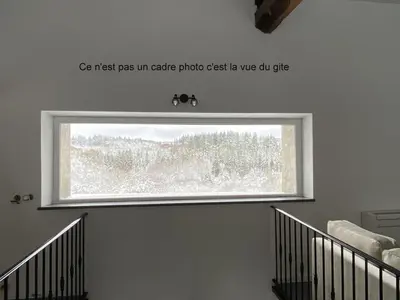 a window in a stairwell with a sign above it at Le Grand Gîte in Le Soulié