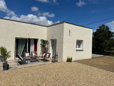 a white house with two chairs on a patio at La Maison Belle Étoile in Limoux